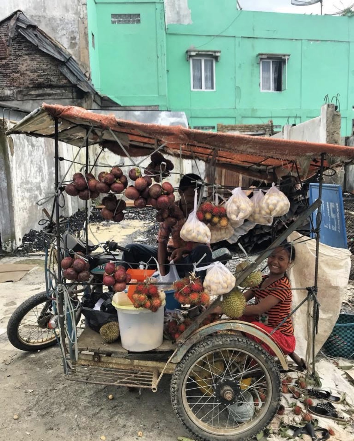 Fruit vendor with a becak cart at a local market in North Sumatra