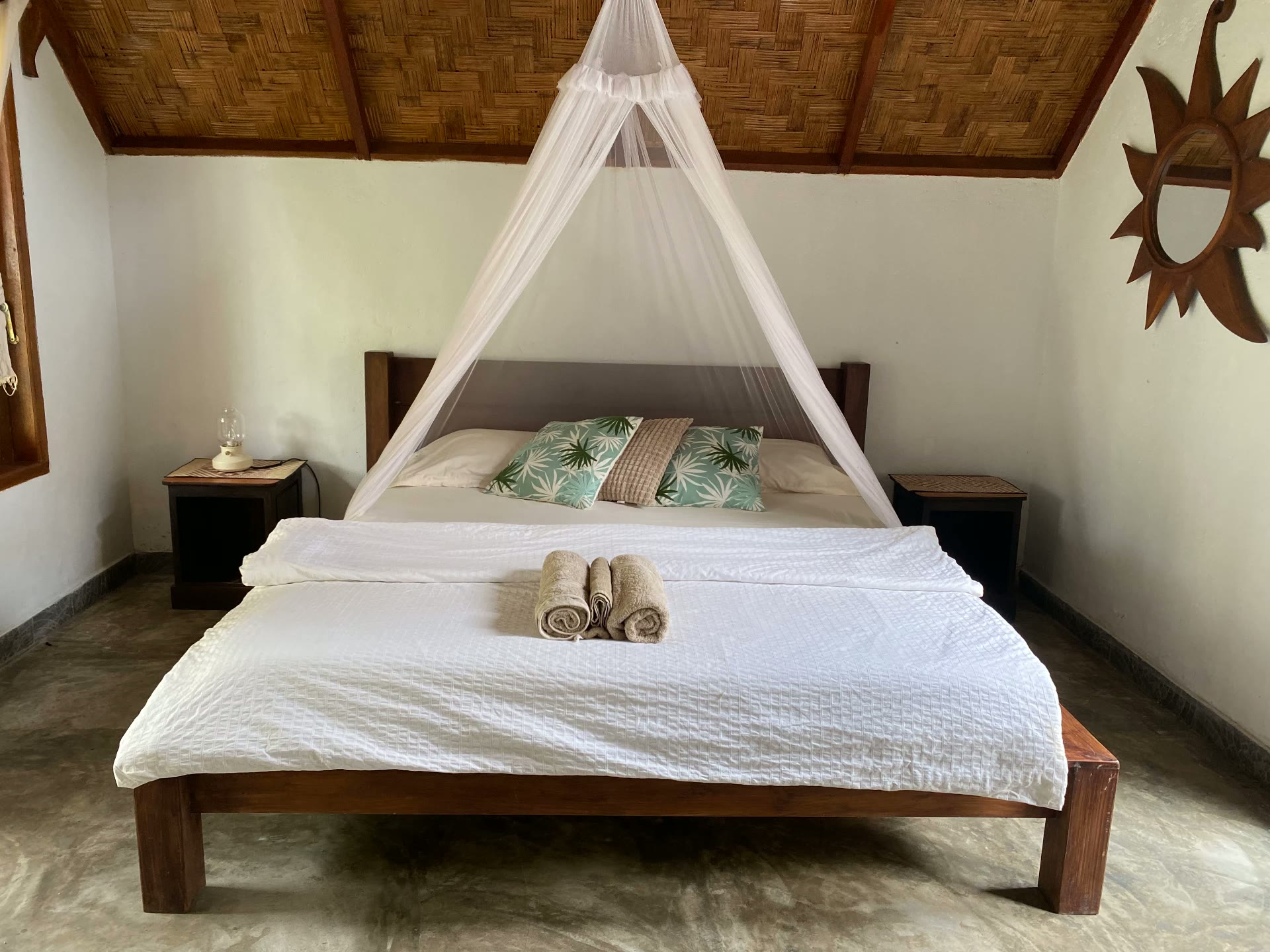 Fan-cooled bungalow with queen-size bed and mosquito net at Villa Paradise guest house in Bukit Lawang, North Sumatra